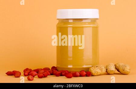 Delicious peanut butter in jar of peanut near on beige background Stock Photo