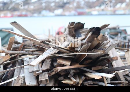 Used timber stacked by lake Stock Photo