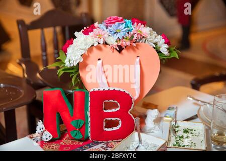 Made letter N and B from red felt. Letter from red and green felt on yellow background. Elementary school. Handmade letter. Bouquet of multi-colored Stock Photo