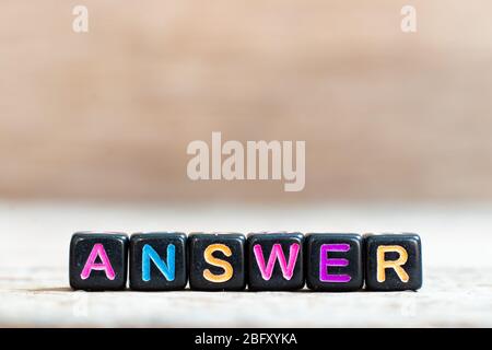 Black bead with color alphabet in word answer on wood background Stock Photo