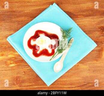 Boiled egg with ketchup on wooden background Stock Photo