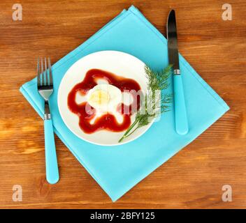 Boiled egg with ketchup on wooden background Stock Photo
