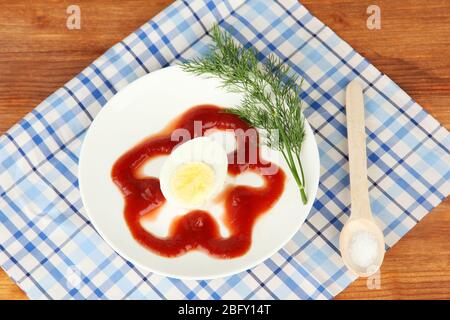 Boiled egg with ketchup on wooden background Stock Photo