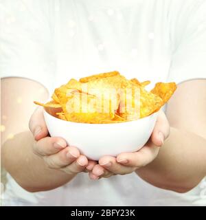 Girl holding at hands chips bowl. Stock Photo
