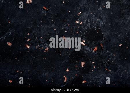 Scattered decorative golden cuts on a black grunge background. Stock Photo