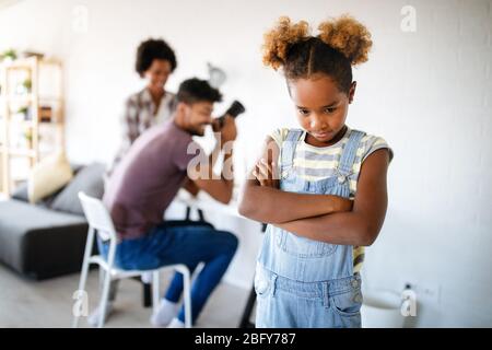 Frustrated sad child looking for attention from busy working parents Stock Photo
