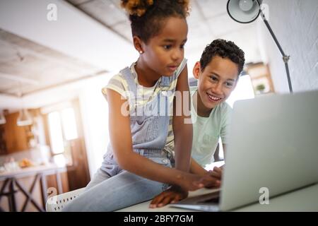 Game, study, fun concept. Happy children spending time with notebook and modern technology. Stock Photo