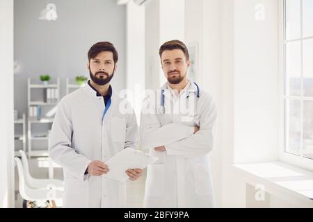 Team of practicing confident medical doctors standing in clinic. Stock Photo