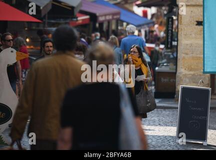 *** STRICTLY NO SALES TO FRENCH MEDIA OR PUBLISHERS - RIGHTS RESERVED *** April 12, 2020 - Paris, France: Parisians wearing face mask shop in rue Mouffetard, one month into a lockdown against the coronavirus outbreak. People can be seen queueing in the street as they wait to enter bakeries, grocery or fish shops. President Macron announced that the lockdown would be lifted on May 11. Stock Photo