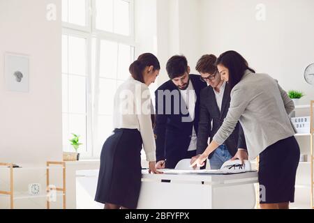 A group of businessmen are working discussing analyzing a project at a table at the workplace in the office. Stock Photo