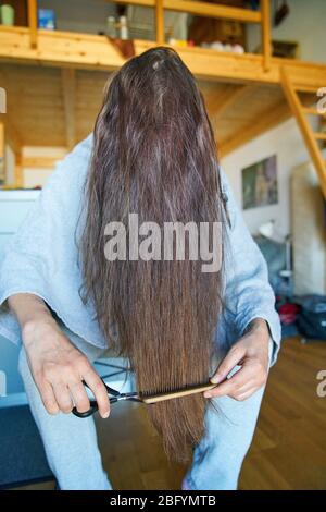 Pfaffenhofen a.d.Ilm, Germany, April 20, 2020. A woman cuts her hair herself on April 20, 2020 in Pfaffenhofen a.d.Ilm, Bavaria, Germany. Due to Corona virus, hair stylists were shut down for many weeks and will open up again soon.  © Peter Schatz / Ģ����ý Live News Stock Photo