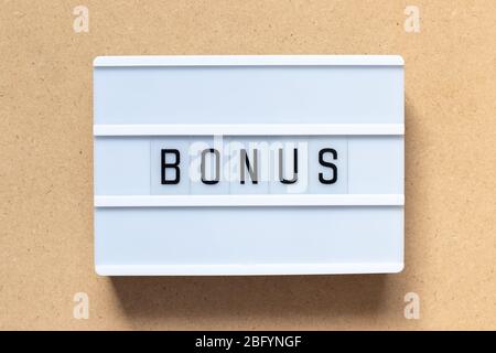 White lightbox with word bonus on wood background Stock Photo