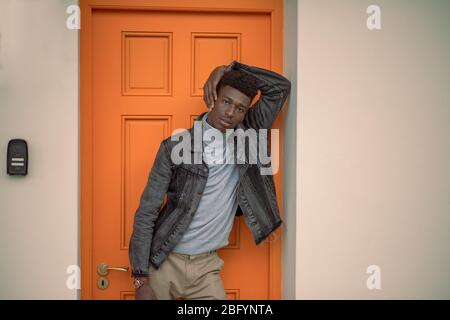 Portrait fo fashionable african man standing against door Stock Photo