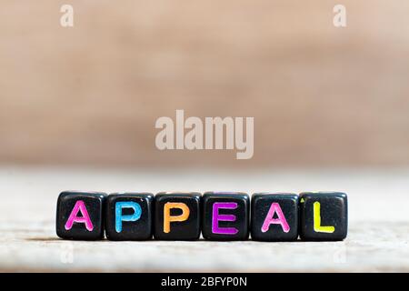 Black bead with color alphabet in word appeal on wood background Stock Photo