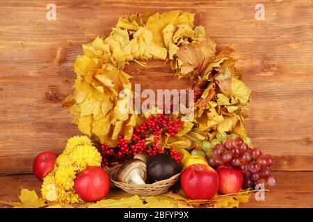 Autumnal composition with yellow leaves, apples and mushrooms on wooden background Stock Photo