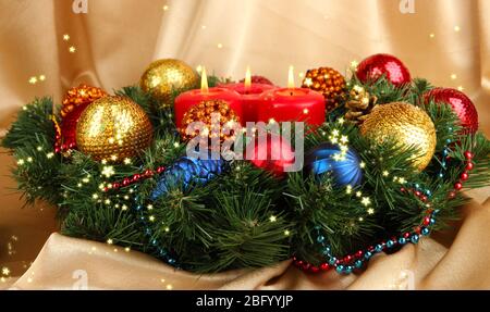 Beautiful Christmas wreath on golden fabric background Stock Photo