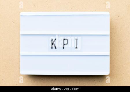 White lightbox with word KPI (Abbreviation of key performance indicator) on wood background Stock Photo