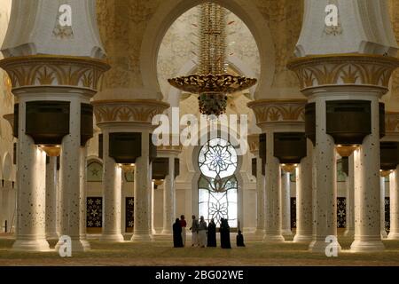 Image ©Licensed to Parsons Media. 20/07/2009. Abu Dhabi, United Kingdom. Tourist stand underneath the worlds largest chandelier inside  The Grand Zayed Mosque in Abu Dhabi the capital of the United  Arab Emirates , it is the largest mosque in the United Arab Emirates and the sixth largest mosque in the world. It is named after Sheikh Zayed bin Sultan Al Nahyan, the founder and the first President of the United Arab Emirates, who is also buried there. The mosque was officially opened in the Islamic month of Ramadan in 2007, It changes colour depending on the moon circle..Picture by Andrew Parso Stock Photo