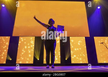 Woman With Success Standing on an Illuminated Stage in Switzerland. Stock Photo