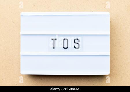 White lightbox with word TOS (abbreviation of Terms of service) on wood background Stock Photo