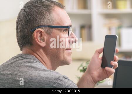 Smiling Deaf man talking using sign language on the smart phone's cam Stock Photo