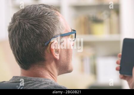 Smiling Deaf man talking using sign language on the smart phone's cam Stock Photo