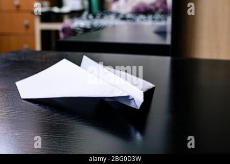 White paper plane on a black wooden table Stock Photo