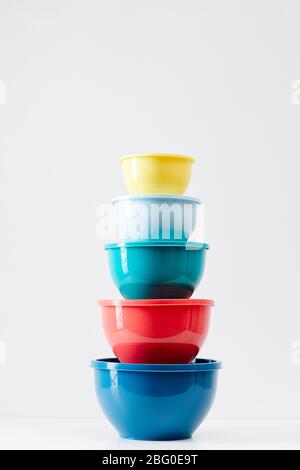 Minimal composition of colorful food containers stacked in row on white background, plastic storage and recycling concept, copy space Stock Photo