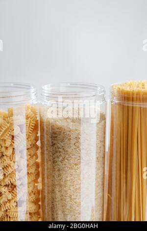 Various pasta and cereal grains in plastic jars for a long storage. Stock Photo