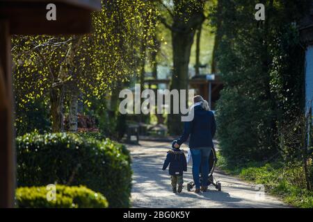 20 April 2020, Schleswig-Holstein, Neumünster: A mother with a child walks along a path of the park shortly after the reopening of the zoo in Neumünster. The zoo was temporarily closed to visitors due to the Corona pandemic. Photo: Gregor Fischer/dpa Stock Photo