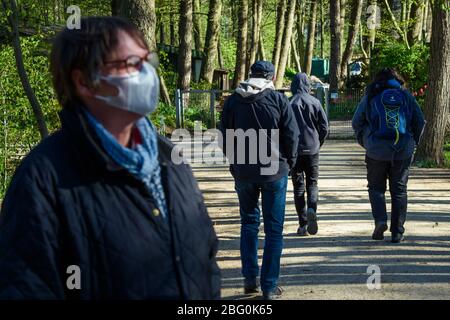 20 April 2020, Schleswig-Holstein, Neumünster: Visitors walk along the paths of the park shortly after the reopening of the zoo in Neumünster. The zoo was temporarily closed to visitors due to the Corona pandemic. Photo: Gregor Fischer/dpa Stock Photo