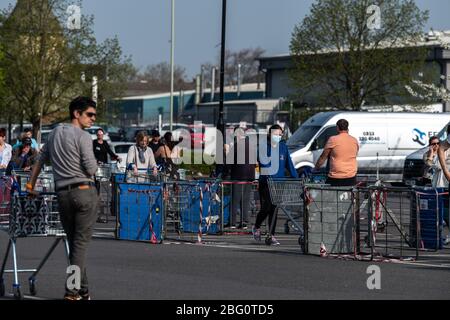 Shoppers wait outside the Tesco Superstore in Cheltenham whilst following the governments social  distancing guidelines. Stock Photo