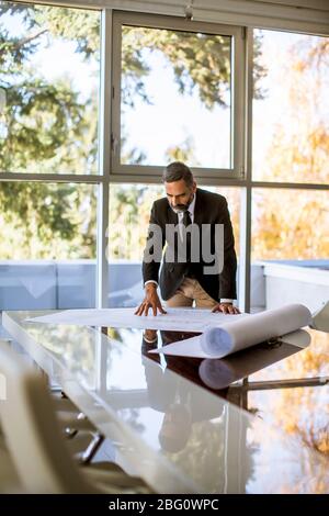 Handsome architect checking plans and blueprints in the office Stock Photo