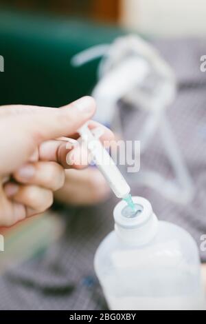 Preparation of compressor nebulizer for use on senior man with respiratory mask, nebulizer in the room Stock Photo