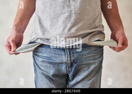 Inverted empty pockets. The young man turned out empty jeans pockets.  Stock Photo