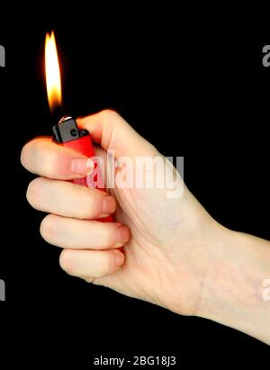 Burning lighter in female hand, isolated on black Stock Photo