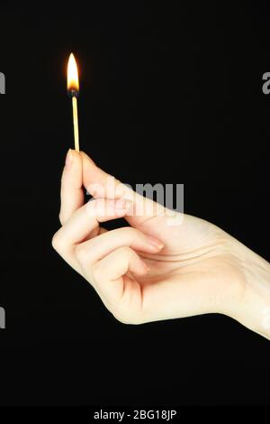 Burning lighter in female hand, isolated on black Stock Photo