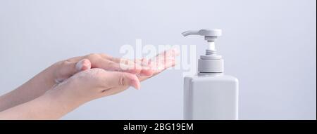 Washing hands. Asian young woman using liquid soap to wash hands, concept of hygiene to protective pandemic coronavirus isolated on gray white backgro Stock Photo