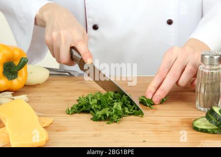 Female hands chopped parsley, isolated on white Stock Photo