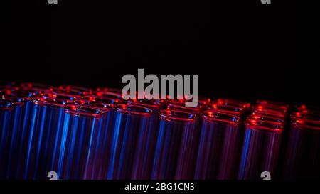 Test tube row. Concept of medical or science laboratory, liquid drop droplet with dropper in blue red tone background, close up, macro photography pic Stock Photo