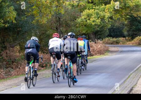 A group of cyclists riding their bikes on country roads in the New forest Hampshire Stock Photo