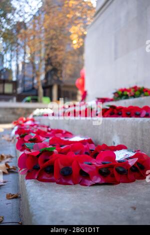 Red poppy wreaths laid around a war memorial for remembrance day