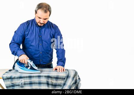 man ironing blue shirt on a white background with copy space for text Stock Photo