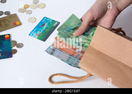 person pulls the money out of the bag. Tenge, Kazakhstan, banknote. Kraft package with paper currency. National currency of Kazakhstan, KZ. Exchange r Stock Photo