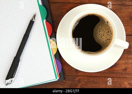 Cup of coffee on worktable covered with documents close up Stock Photo