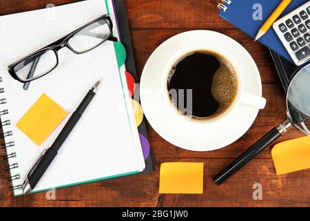 Cup of coffee on worktable covered with documents close up Stock Photo
