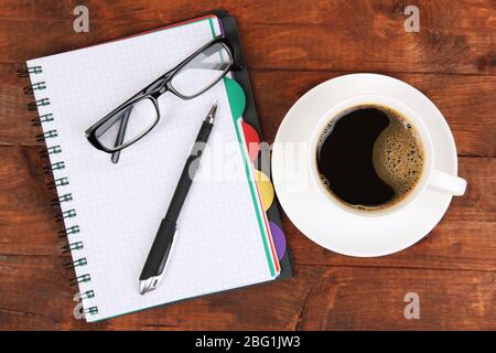 Cup of coffee on worktable covered with documents close up Stock Photo