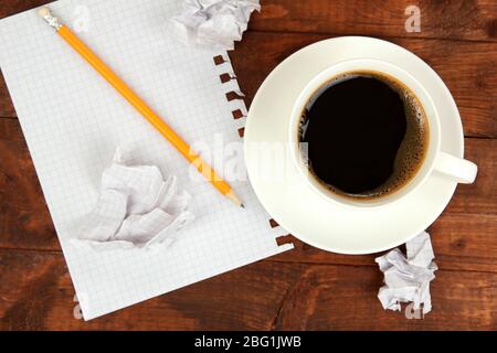 Cup of coffee on worktable covered with documents close up Stock Photo