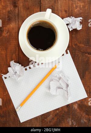 Cup of coffee on worktable covered with documents close up Stock Photo