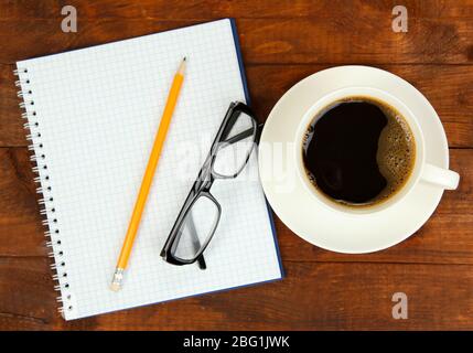 Cup of coffee on worktable covered with documents close up Stock Photo